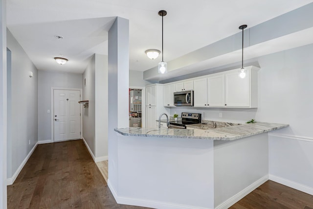 kitchen with kitchen peninsula, appliances with stainless steel finishes, dark hardwood / wood-style floors, white cabinetry, and hanging light fixtures