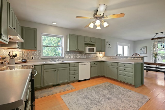 kitchen featuring white appliances, light hardwood / wood-style floors, green cabinetry, and sink