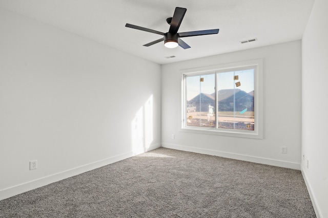 carpeted spare room with ceiling fan