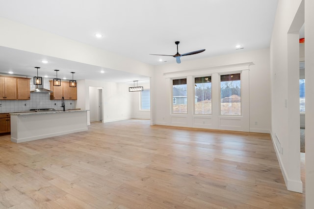 unfurnished living room with ceiling fan and light hardwood / wood-style flooring