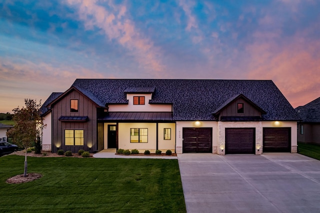 modern farmhouse style home with a lawn and a garage