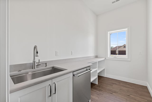 kitchen with stainless steel dishwasher, dark hardwood / wood-style floors, white cabinetry, and sink