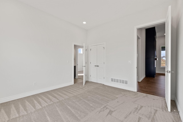 unfurnished bedroom featuring light carpet