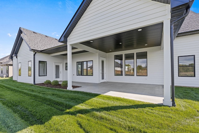 rear view of house featuring a patio area and a yard