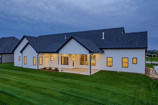 rear view of house featuring a yard and a patio