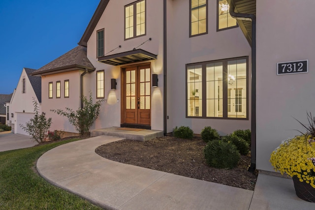 entrance to property featuring a garage and french doors