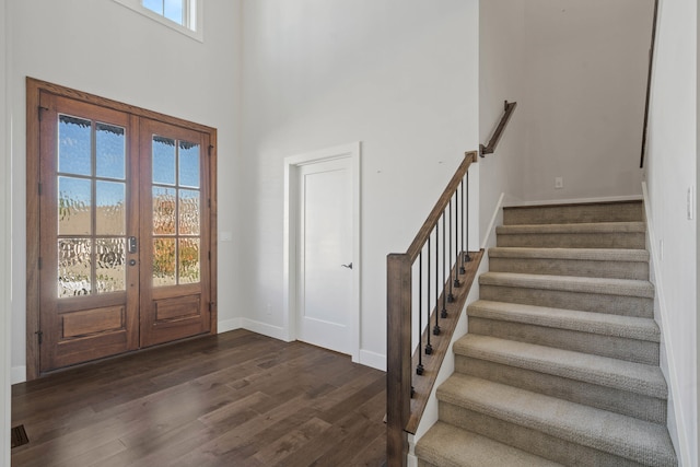 entryway featuring french doors, a towering ceiling, and dark hardwood / wood-style flooring