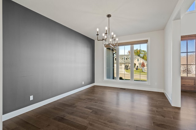 unfurnished dining area with a chandelier and dark hardwood / wood-style floors