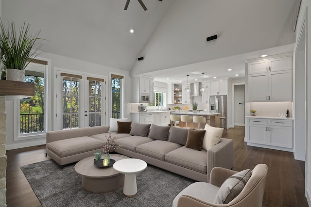 living room featuring dark hardwood / wood-style floors, ceiling fan, sink, and high vaulted ceiling