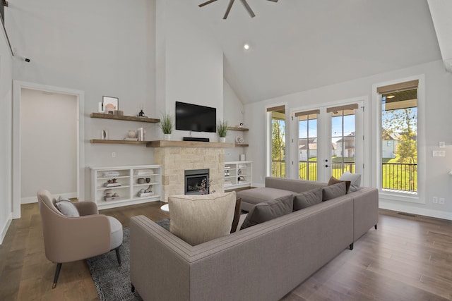 living room featuring ceiling fan, french doors, high vaulted ceiling, wood-type flooring, and a fireplace