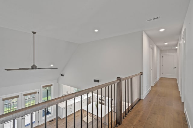 corridor featuring light hardwood / wood-style floors and lofted ceiling