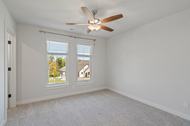 carpeted spare room featuring ceiling fan