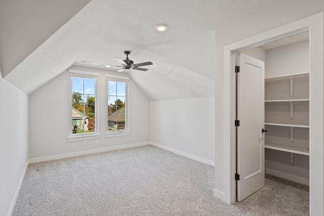 bonus room with vaulted ceiling, ceiling fan, light carpet, and a textured ceiling