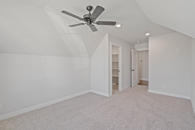 bonus room featuring a textured ceiling, light colored carpet, ceiling fan, and lofted ceiling