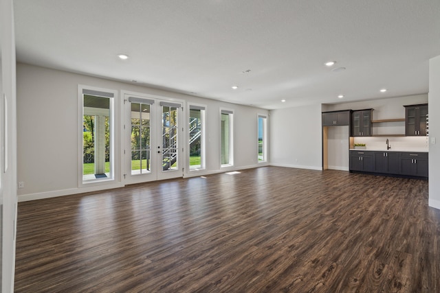 unfurnished living room with french doors, dark wood-type flooring, and sink