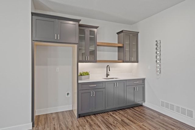 kitchen featuring gray cabinets, sink, and dark wood-type flooring