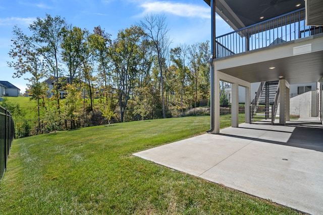 view of yard featuring a patio, a balcony, and ceiling fan