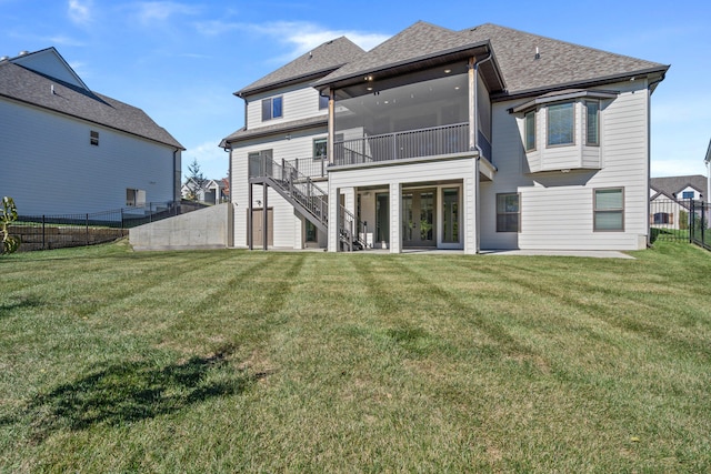 back of property featuring a sunroom and a lawn