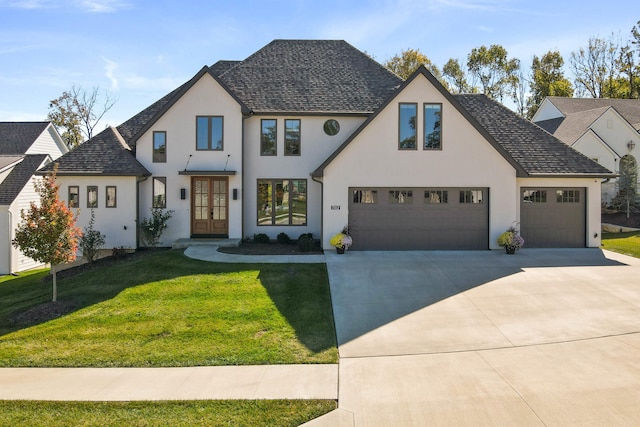 view of front facade with french doors, a garage, and a front lawn