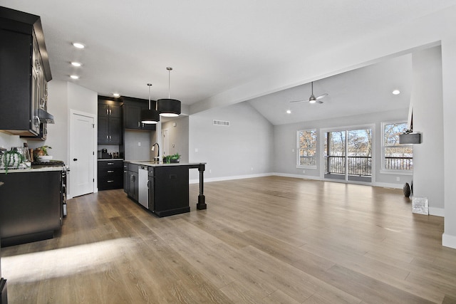 kitchen with ceiling fan, sink, an island with sink, pendant lighting, and lofted ceiling