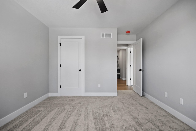 unfurnished bedroom with light colored carpet and ceiling fan