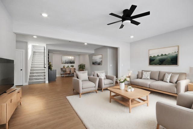 living room with ceiling fan and light hardwood / wood-style flooring