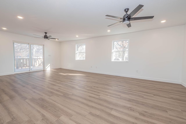 empty room with ceiling fan, recessed lighting, light wood-type flooring, and baseboards