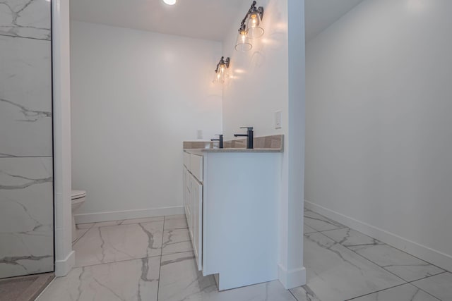 full bath featuring vanity, toilet, baseboards, and marble finish floor