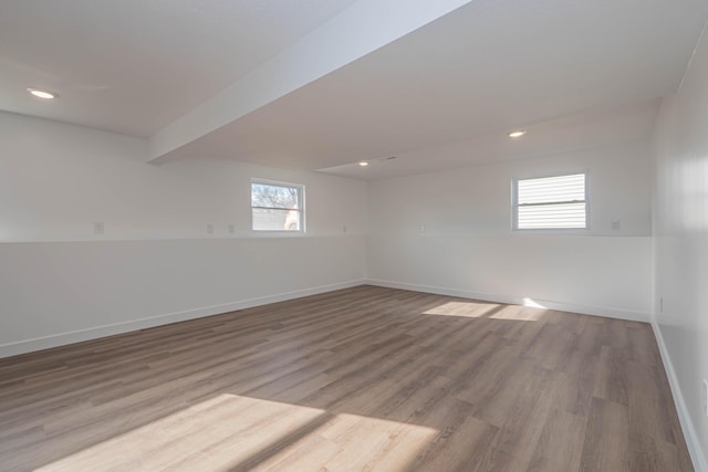 spare room with recessed lighting, beamed ceiling, baseboards, and wood finished floors