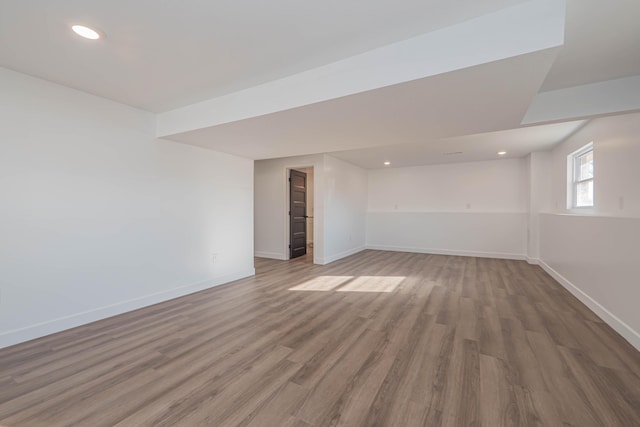 unfurnished room featuring recessed lighting, wood finished floors, and baseboards