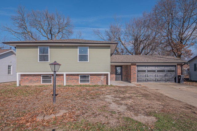 split level home featuring concrete driveway, an attached garage, and brick siding