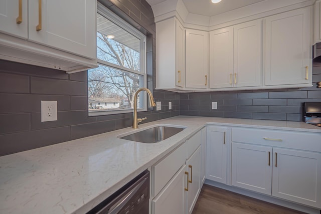 kitchen featuring a sink, dark wood-style floors, white cabinetry, decorative backsplash, and light stone countertops