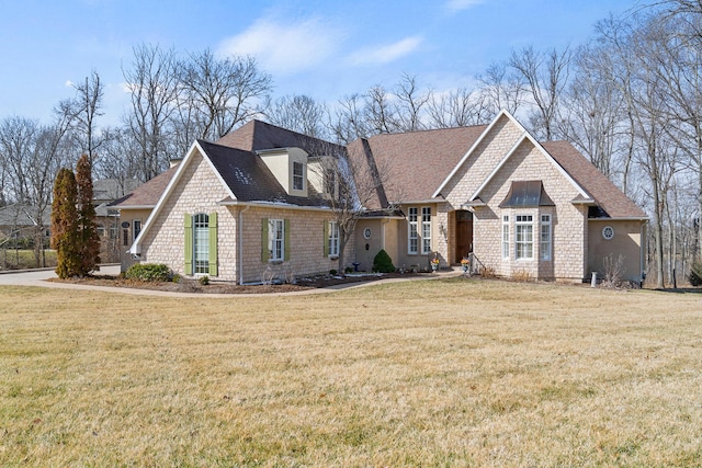 view of front of house with a shingled roof and a front yard