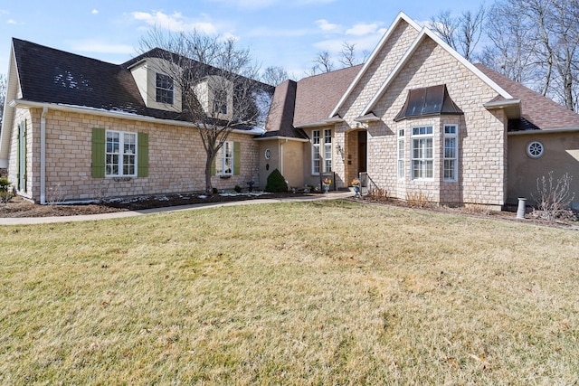 view of front facade with a front yard and roof with shingles