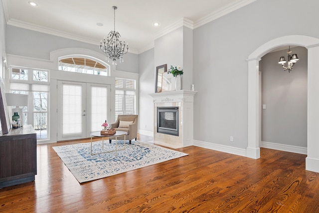 foyer with arched walkways, wood finished floors, and a notable chandelier