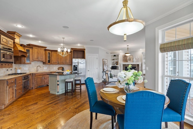 dining room with recessed lighting, a notable chandelier, crown molding, and wood finished floors