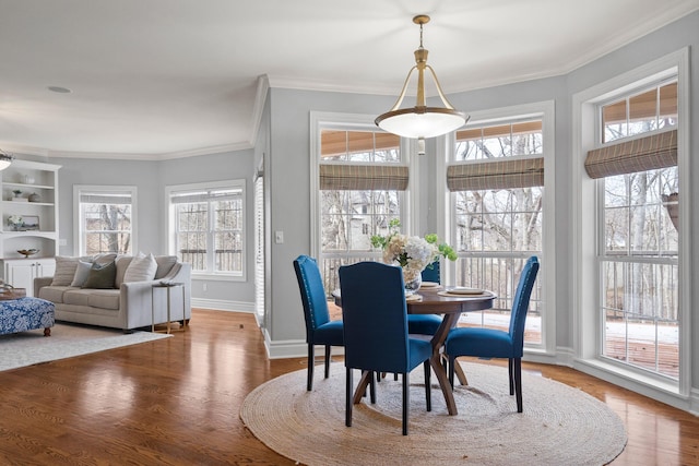 dining room with ornamental molding, plenty of natural light, and wood finished floors