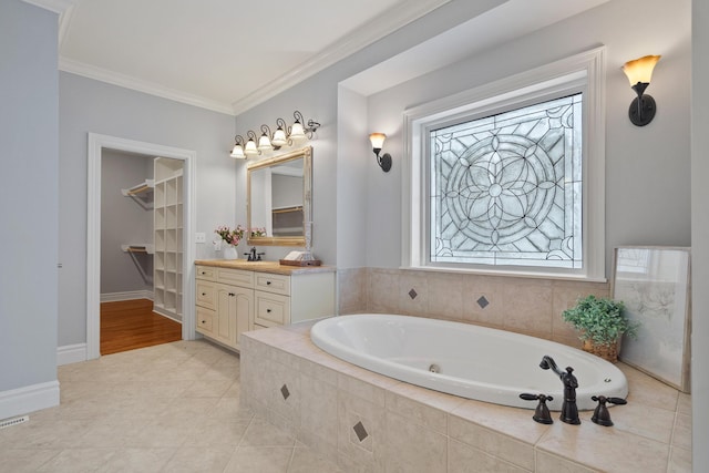 full bath featuring baseboards, ornamental molding, a whirlpool tub, a spacious closet, and vanity