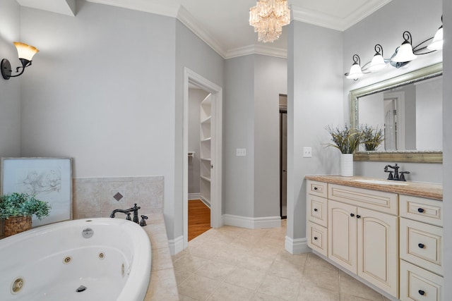 full bath with baseboards, ornamental molding, a tub with jets, tile patterned floors, and vanity