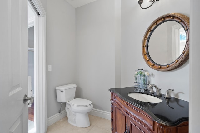 bathroom featuring tile patterned flooring, baseboards, vanity, and toilet