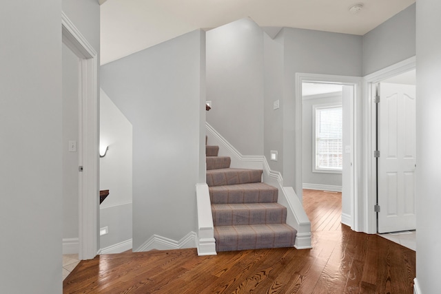 stairway with baseboards and wood finished floors