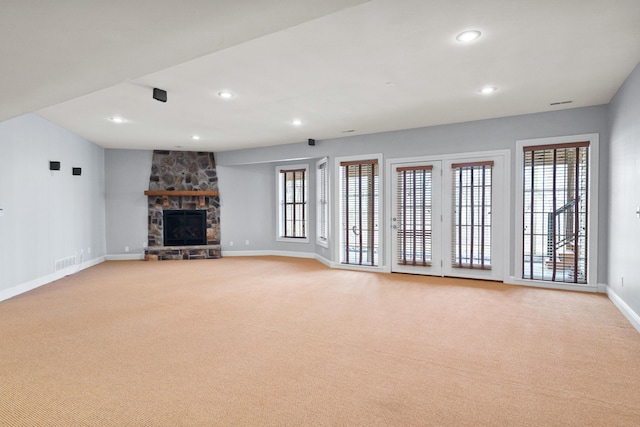 unfurnished living room featuring recessed lighting, a fireplace, baseboards, and light colored carpet