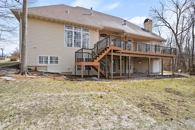 back of property featuring a shingled roof, a patio, a chimney, stairway, and a deck