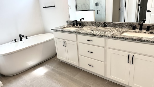 bathroom with tile patterned floors, vanity, and shower with separate bathtub