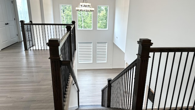 stairs featuring hardwood / wood-style floors and a notable chandelier