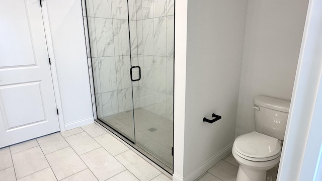 bathroom with tile patterned flooring, toilet, and a shower with shower door