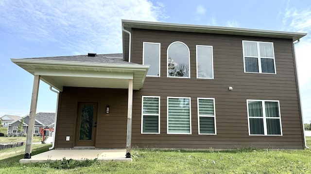 rear view of house featuring a lawn and a patio area