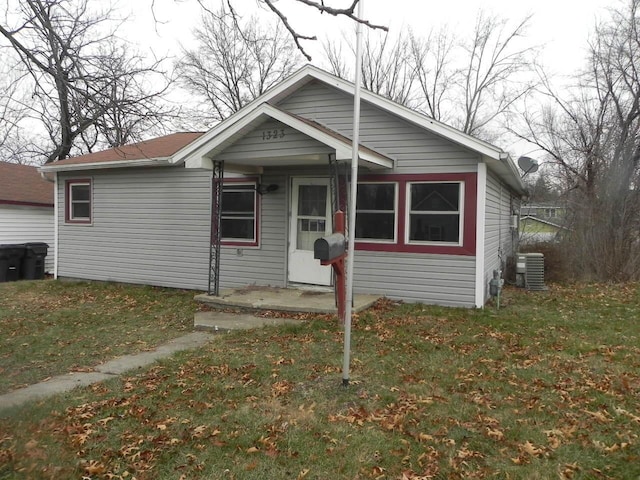 bungalow-style house with central AC and a front lawn