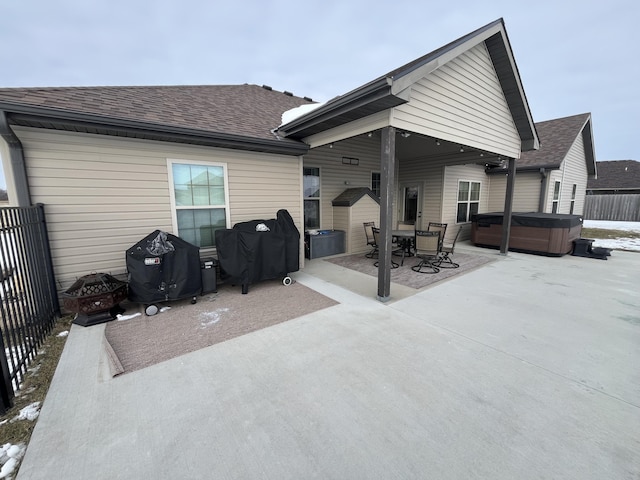 rear view of house with a hot tub and a patio area