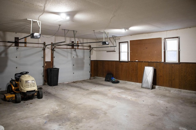 garage with a garage door opener and wood walls